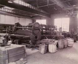 Old factory image with equipment and barrels.